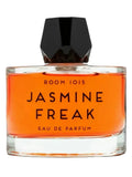 A bottle of Room 1015 Jasmine Freak Eau de Parfum with bright orange liquid and a black faceted cap, set against a solid black background.